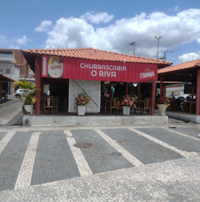 Fachada vermelha da churrascaria em frente à praça